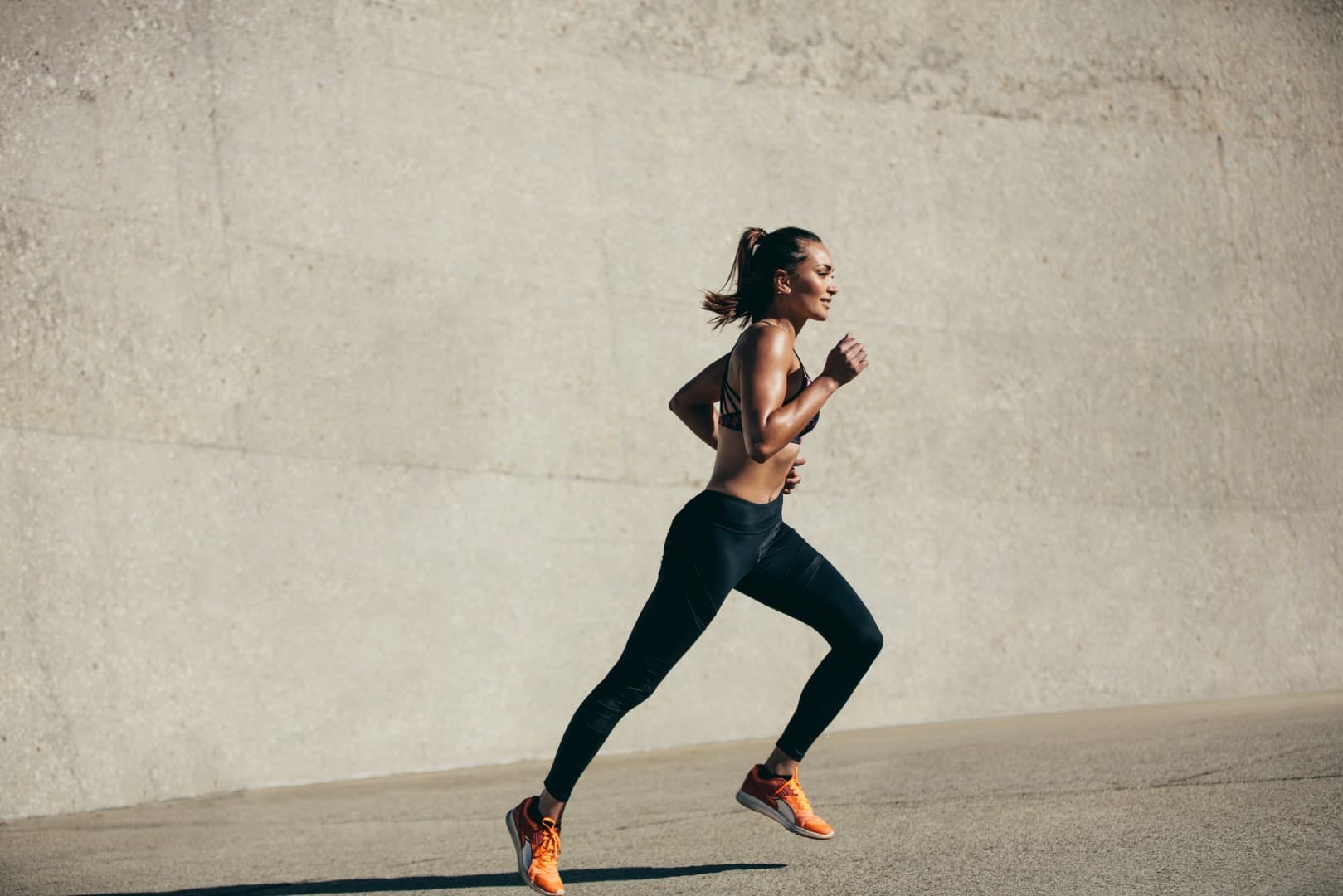 Nationwide, a woman running outdoors along a sunlit wall
